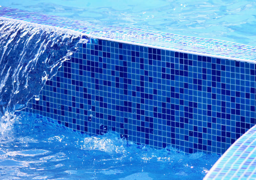 Water in the pool on the background of blue ceramic tiles