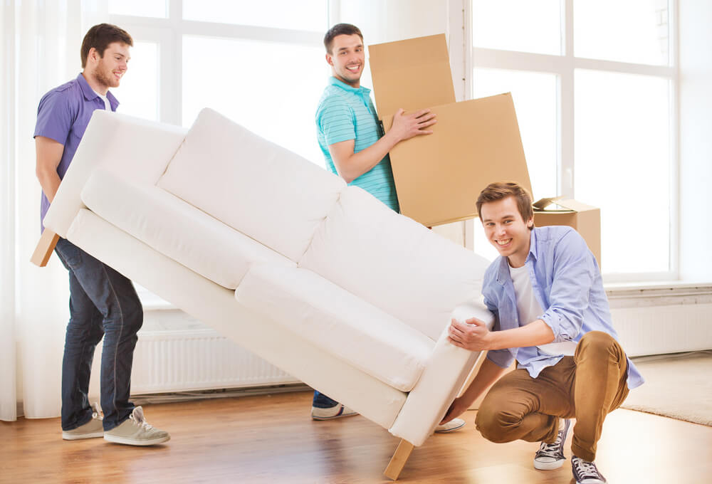 Repair, Furniture, Decorating and Home Concept - Smiling Friends With Sofa and Cardboard Boxes