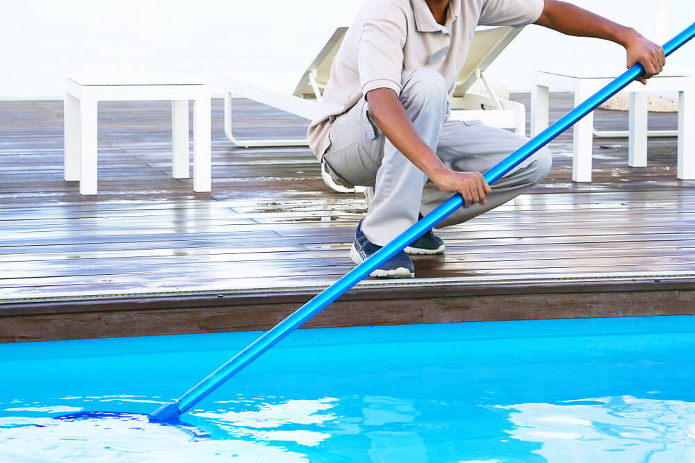Hotel Staff Worker Cleaning the Pool.