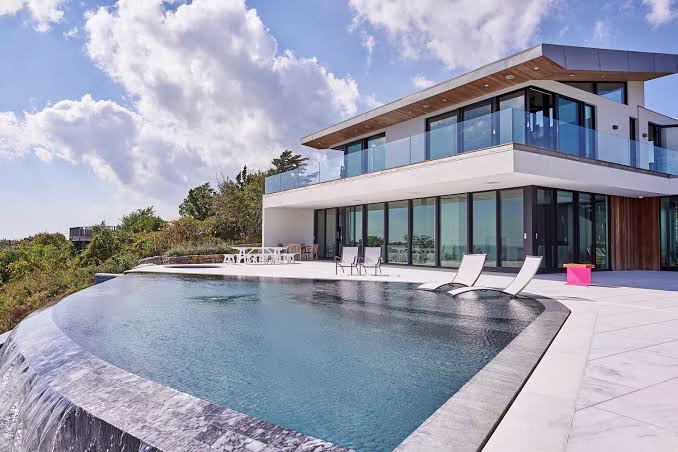 Infinity-edge pool with a cascading waterfall feature, showcasing a modern Swimming Pool Design Naples.